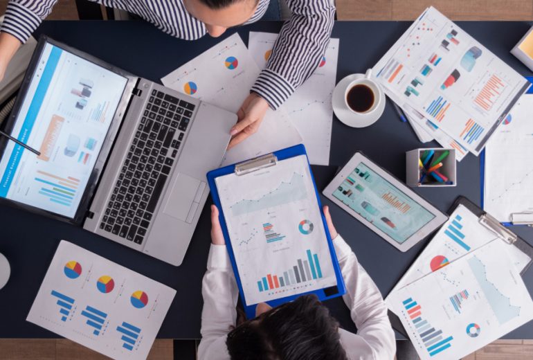 top-viewtop-view-manager-employee-doing-teamwork-business-office-looking-charts-laptop-display (1)